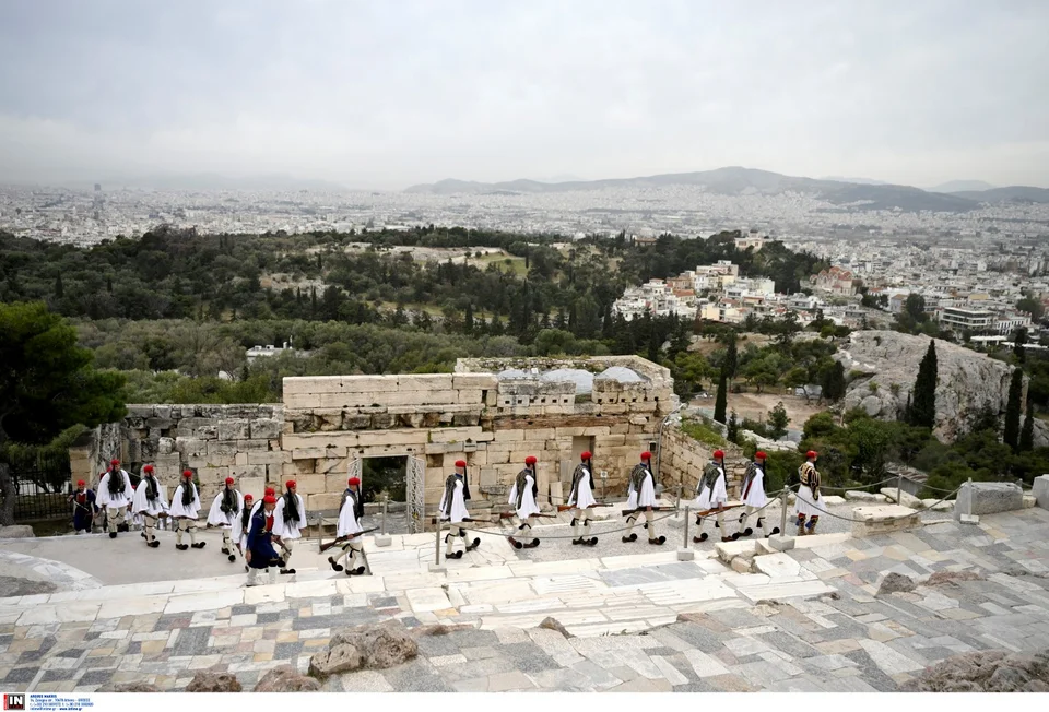 a group of people in red hats walking on a stone staircase